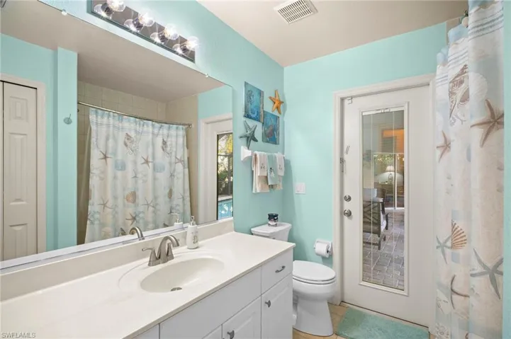 Full bath with a shower with curtain, vanity, and light tile patterned flooring