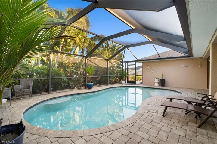 Outdoor pool with a sunroom, a patio, and glass enclosure