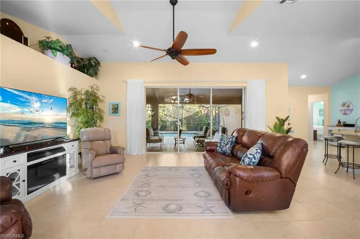 Living area with light tile patterned floors, ceiling fan, and recessed lighting
