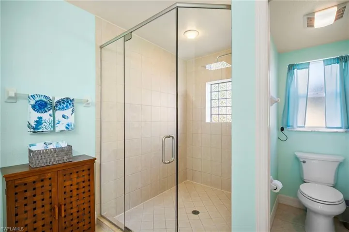 Full bath with a shower stall and tile patterned flooring