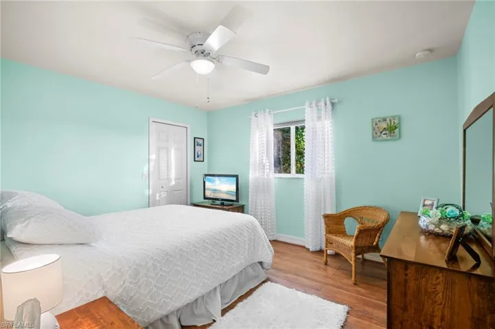 Bedroom with a closet, wood finished floors, and ceiling fan
