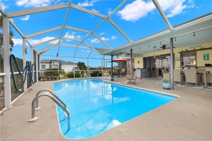 Large screened saltwater pool surrounded by tropical landscaping