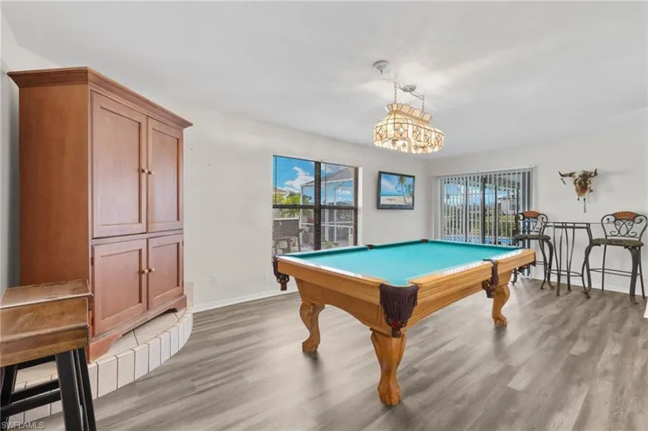 Bonus living space is being used as a game room and also walks out to the pool area