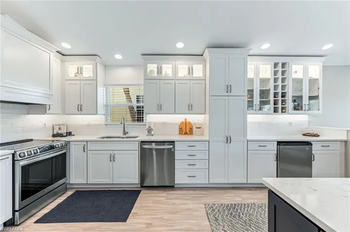 The designer kitchen with stainless steel appliances, Quartz Countertops, back lit cabinets  and free-standing Island