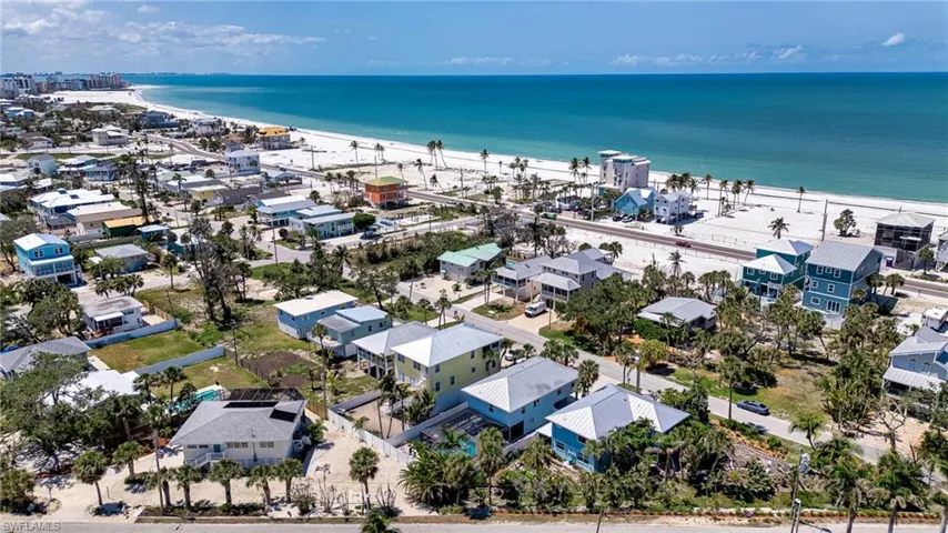Aerial view of residential area featuring waterfront with a beach