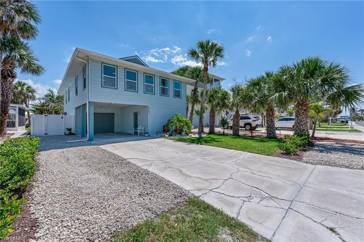 Coastal home featuring expanded driveway for guests an attached garage.