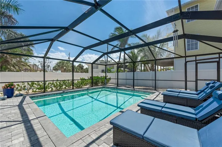 View of swimming pool with a fenced backyard, a patio area, and glass enclosure
