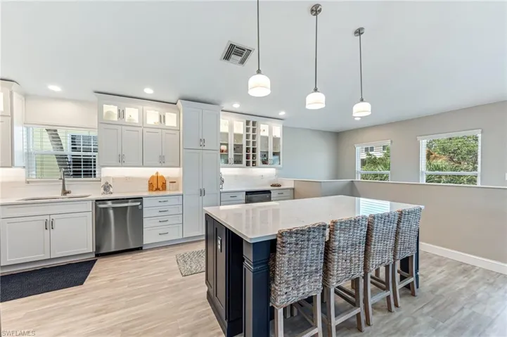 The spacious Kitchen with decorative pendant lighting flows seamlessly to the Living room