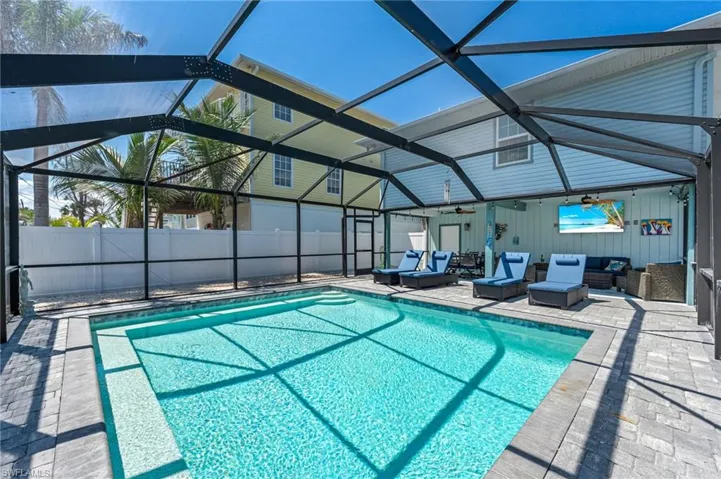 View of swimming pool with an outdoor hangout area, ceiling fan, a patio area, glass enclosure, and fence
