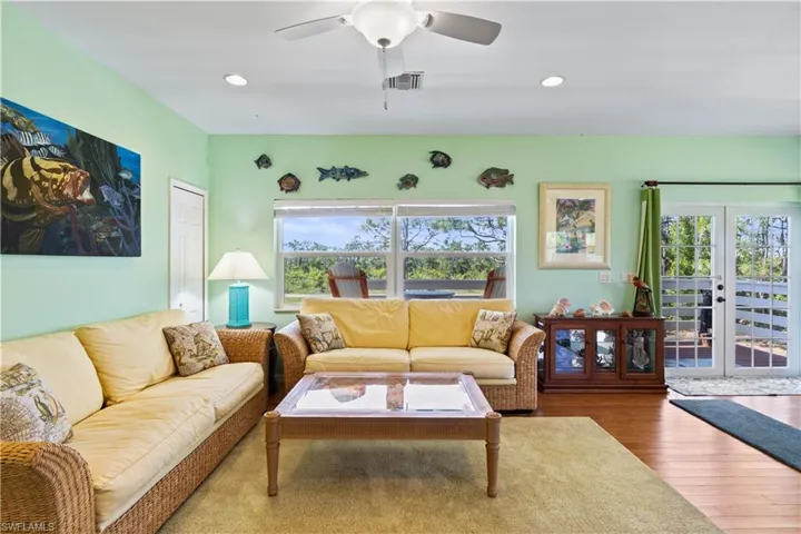 A sprawling great room with beautiful wood floors, vibrant island colors and a large living space that is open to the kitchen and dining area.