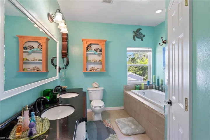 Master bath features a beautiful jetted soaking tub, shower and updated vanities.