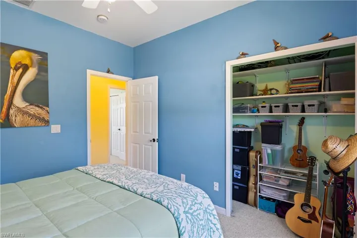 Guest bedroom # 2 with plenty of storage and vibrant blue color.  This room also has a beautiful natural Berber carpet.