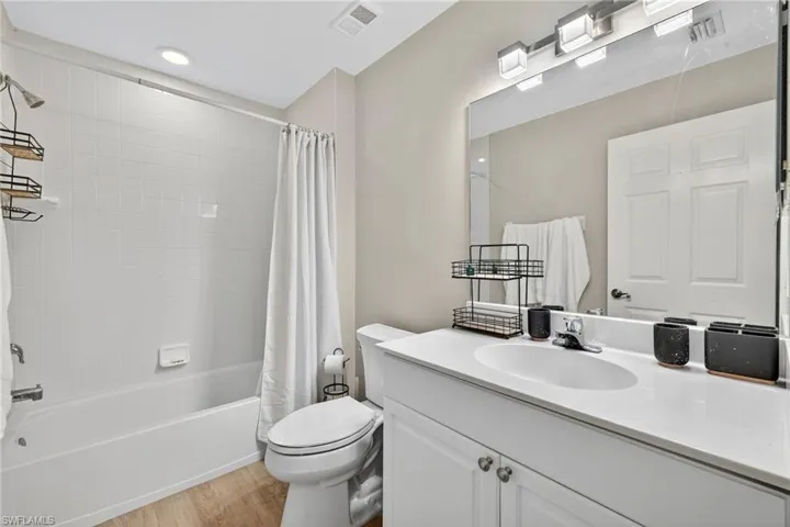 Bathroom featuring shower / bath combo, light wood-type flooring, and vanity