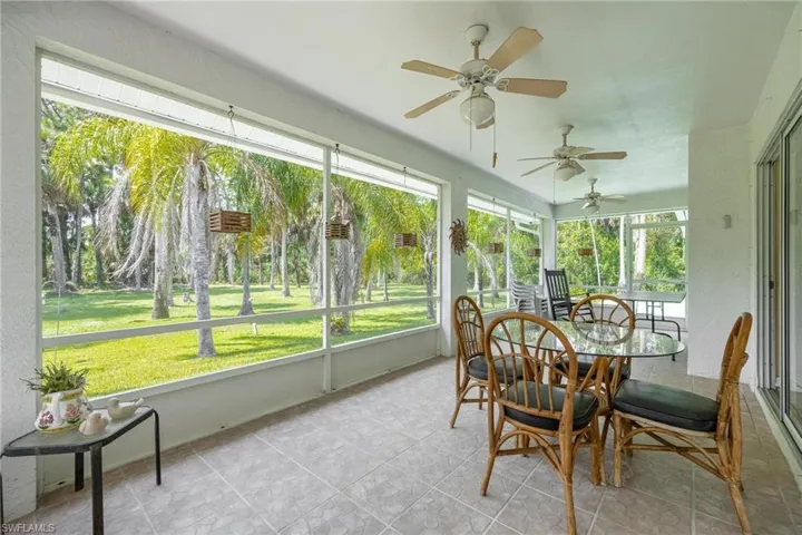 Spacious sunroom featuring ceiling fans.