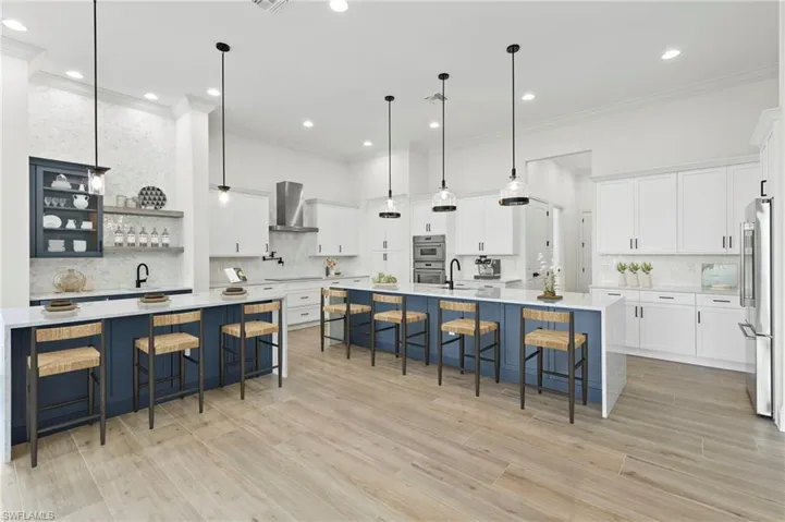 Kitchen with a spacious island, appliances with stainless steel finishes, a breakfast bar area, and pendant lighting