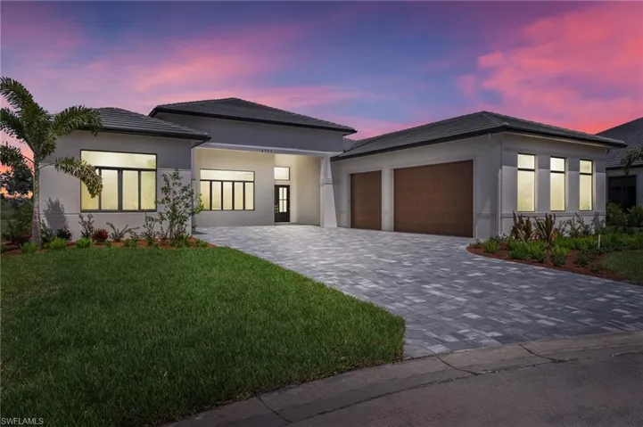 View of front facade featuring a yard and a garage