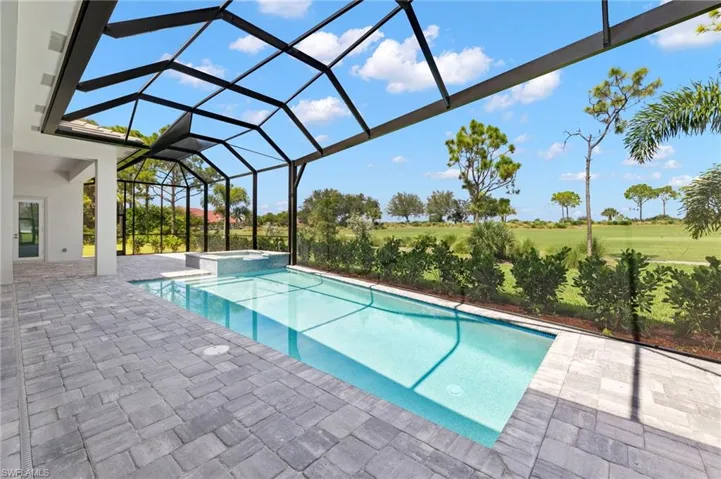 View of swimming pool with an in ground hot tub, a patio area, and a lanai