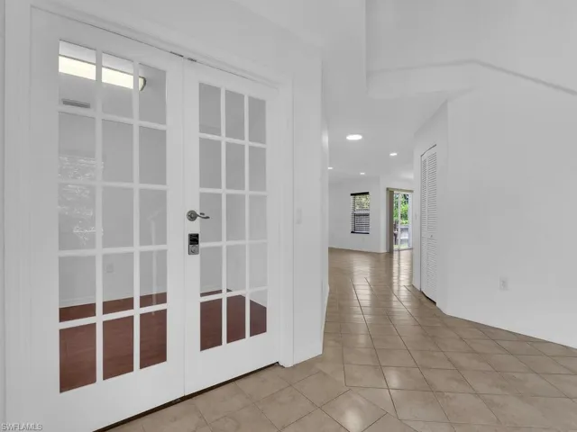 Hallway featuring tile patterned flooring, french doors, and recessed lighting