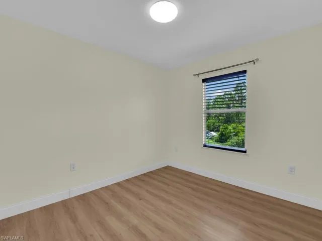 Empty room with baseboards and light wood finished floors