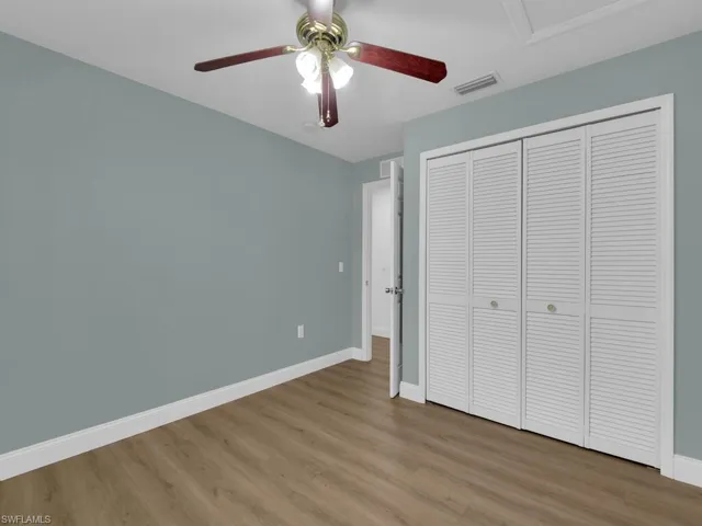 Unfurnished bedroom with light wood-style floors, a closet, and a ceiling fan