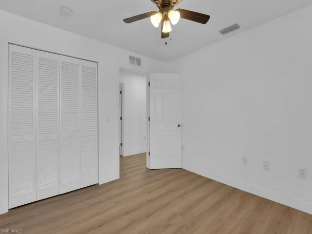 Unfurnished bedroom featuring light wood finished floors, a closet, and a ceiling fan