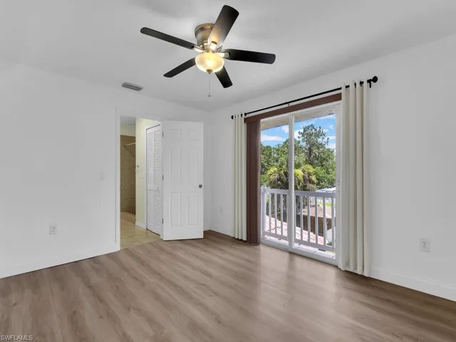 Empty room with wood finished floors and a ceiling fan