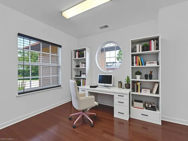 Office area with dark wood-type flooring and baseboards