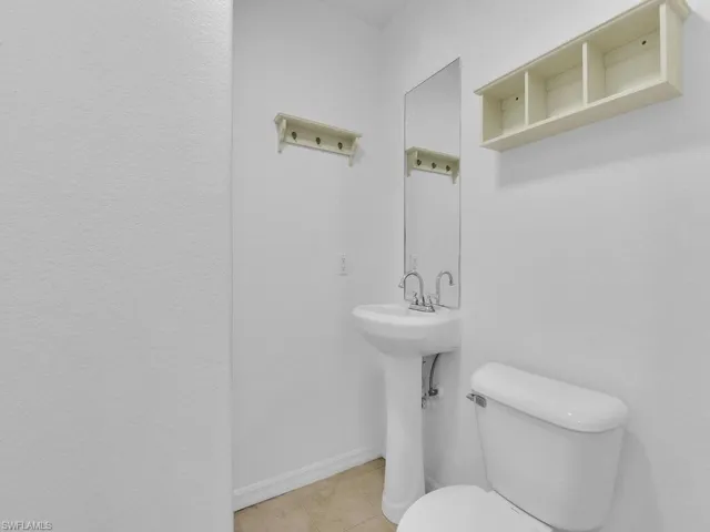 Half bathroom with toilet and tile patterned flooring