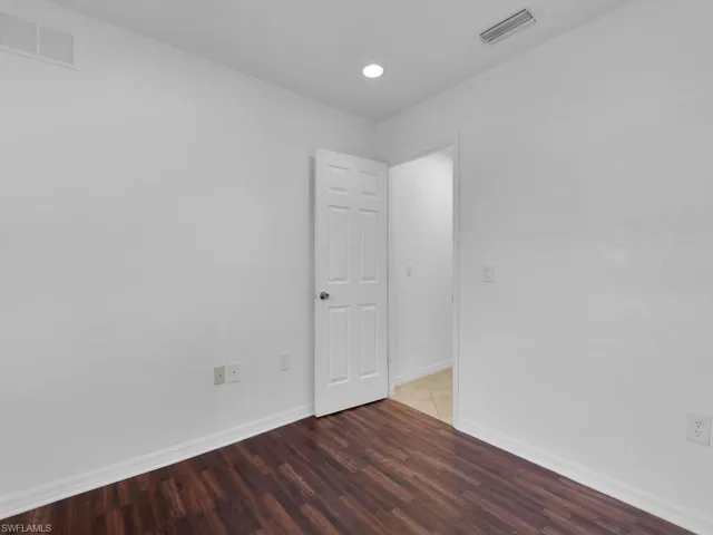 Unfurnished room with wood finished floors and recessed lighting