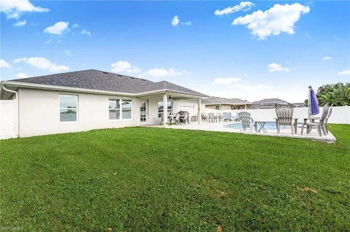 Rear view of property featuring a patio, a fenced backyard, stucco siding, and roof with shingles