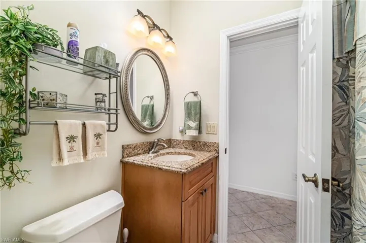 Bathroom with vanity, light tile patterned floors, and crown molding