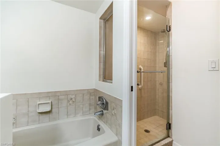 Bathroom with a shower stall and a bath
