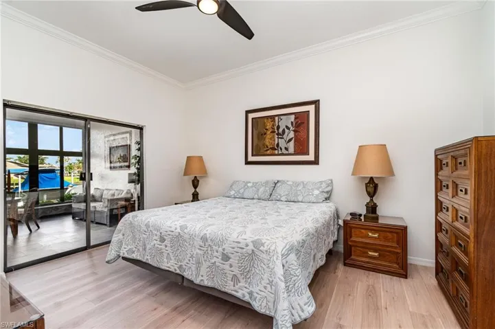 Bedroom featuring ornamental molding, light wood finished floors, access to outside, and ceiling fan
