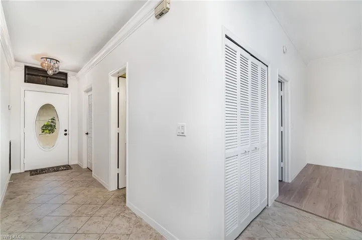 Foyer entrance featuring ornamental molding and light tile patterned floors