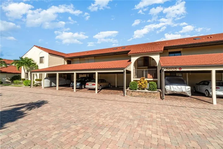Mediterranean / spanish home featuring stucco siding, a tile roof, and covered parking