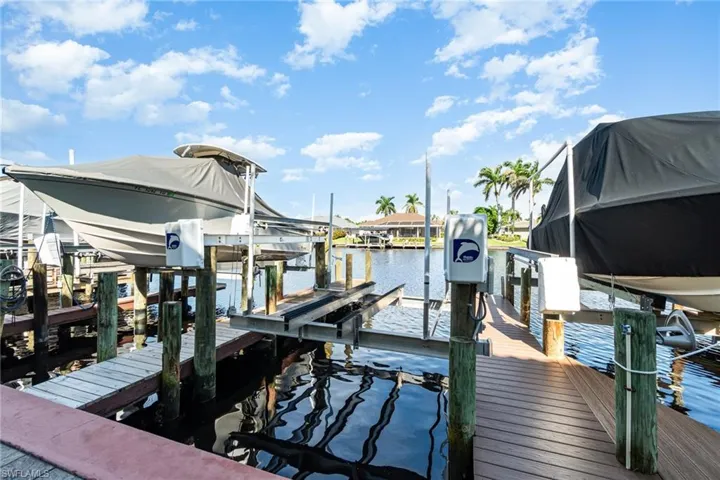 Dock area with boat lift and a water view