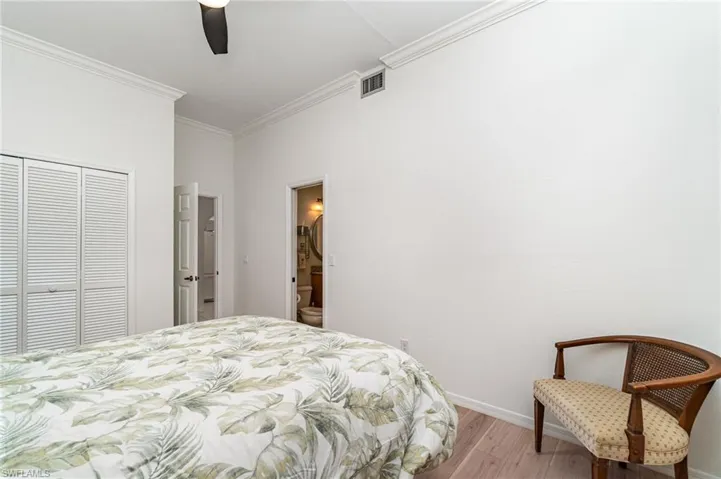 Bedroom featuring wood finished floors, ornamental molding, a closet, and ceiling fan
