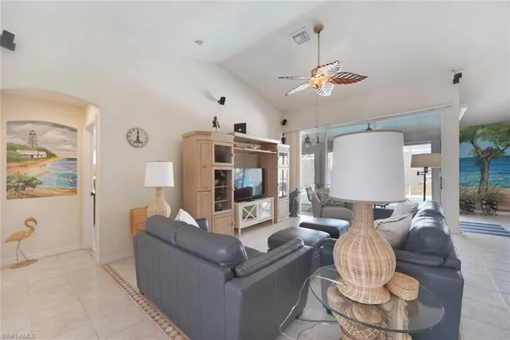 Great room with volume ceiling, listello tile accents along floor and tropical murals on walls