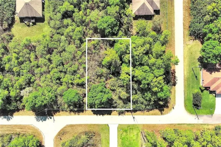 Aerial view of property and surrounding area featuring property parcel outlined
