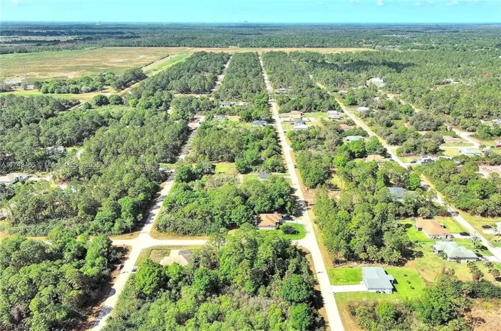View of property location with a heavily wooded area