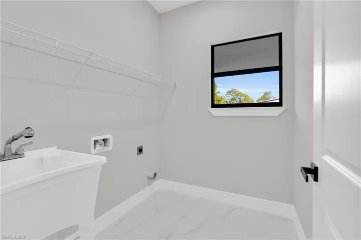 Laundry room featuring marble finish floors, hookup for a washing machine, and hookup for an electric dryer