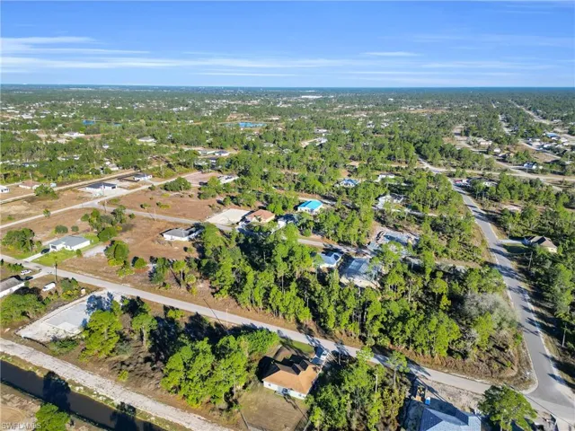 Aerial view of property and surrounding area with nearby suburban area