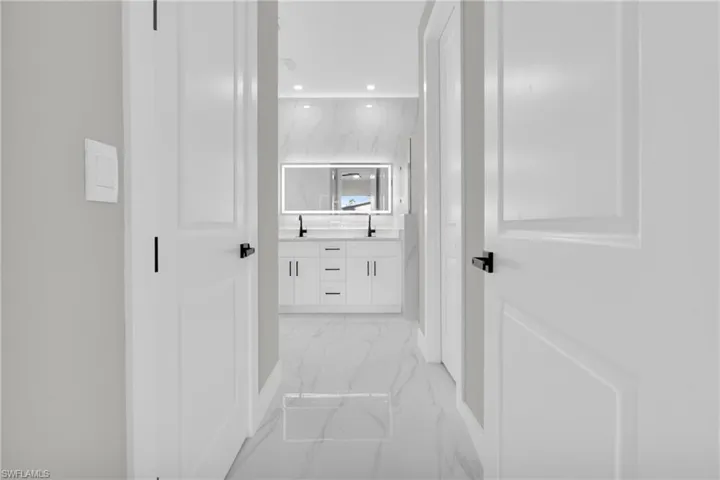 Hallway featuring light marble finish floors and recessed lighting