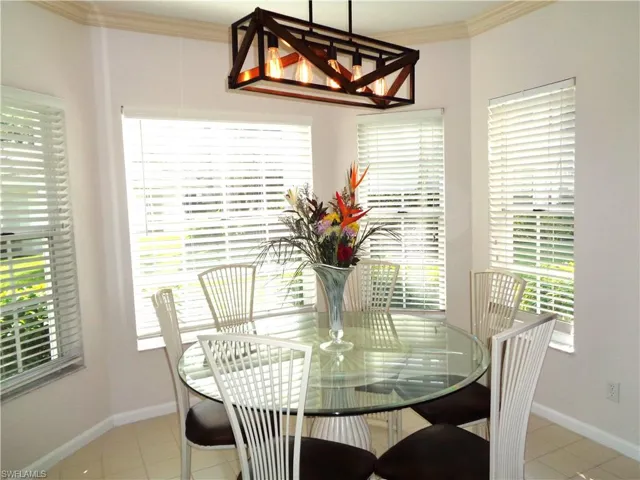 Tiled dining space with plenty of natural light and ornamental molding