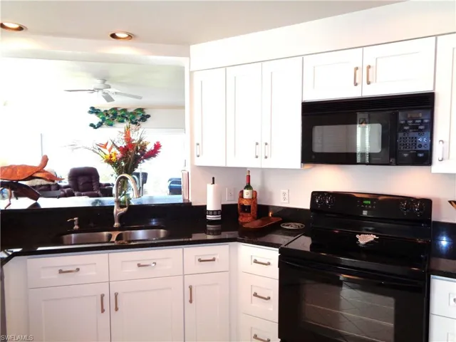 Kitchen featuring black appliances, a ceiling fan, white cabinets, dark countertops, and recessed lighting
