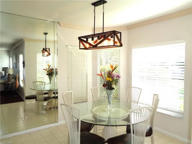 Tiled dining room featuring ornamental molding