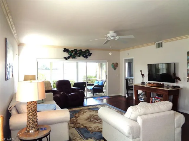 Living area featuring ornamental molding, a ceiling fan, and wood finished floors