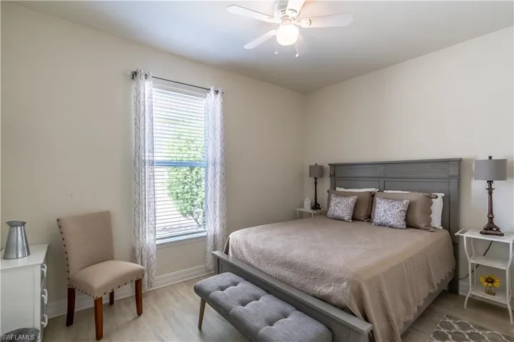Bedroom with ceiling fan, multiple windows, and light wood-type flooring