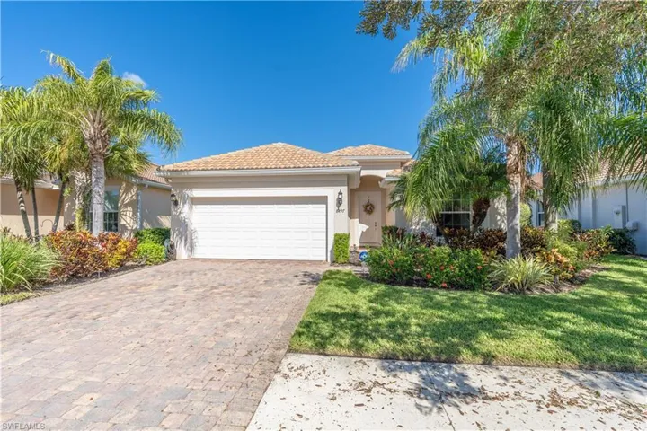 Mediterranean / spanish-style house with a garage and a front lawn