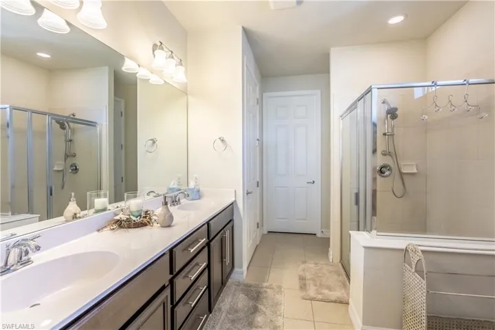 Bathroom with vanity, walk in shower, and tile patterned floors